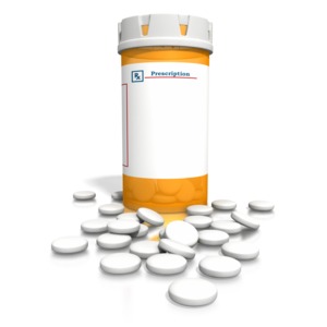 This image contains an orange blank pill bottle with white tablets spread out on ground.