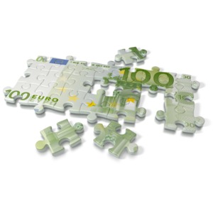 An image of a 100 Euro, the currency of the European Union, on a puzzle.  A concept of solving a financial problem or building a business.