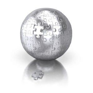 An image of a silver sphere of connected puzzle pieces with one piece on the ground.