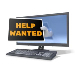 &lt;p&gt;A hand hold out a help wanted sign from a computer monitor. A concept of job hunting on-line or looking for work.&lt;/p&gt;