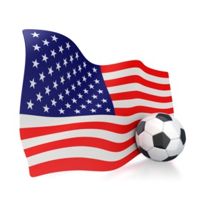 This clip art image shows an American flag with a soccer ball sitting next to it.  