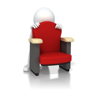 A stick figure crouches behind his theater chair scared or hiding from what is in front of him.  A concept of a frightened audience or watching something scary.