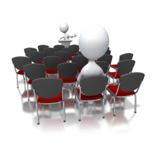 An image of a stick figure at a podium speaking to one person.