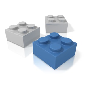 A group of three toy building blocks.  One of the build blocks is blue.  A concept of puzzle pieces, or the key piece in a solution.  These building bricks are generic and could represent building a business or construction of a concept.