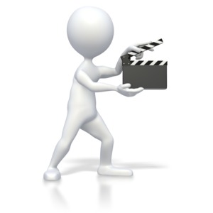 A stick figure hold a movie clap board in this clip art image.