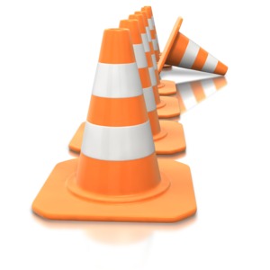 An image of a line of construction cones with one tipped over.