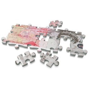 An image of a fifty pound, the currency of the United Kingdom, on a puzzle.  A concept of solving a financial problem or building a business.