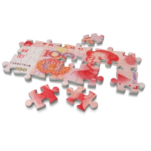 An image of a 100 Renminbi, the currency of the People&#039;s Republic of China, on a puzzle.  A concept of solving a financial problem or building a business.