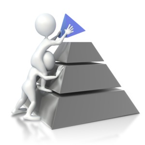 Two 3D stick figures work together to place the tip of the pyramid on top.  A concept of achievement, reaching a goal, or striving for quality or to be the best.