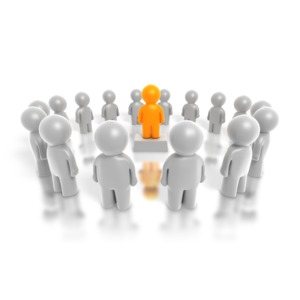 A single highlighted figure stands at the center of a circle of people.  A concept of leadership.