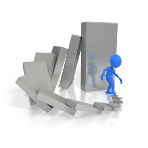 A single blue stick figure starts a chain reaction by tipping over a domino.  A series of increasing bigger dominoes surround the figure and are in danger of squashing the figure.  A concept of cause and effect or not realizing the consequences of our actions.