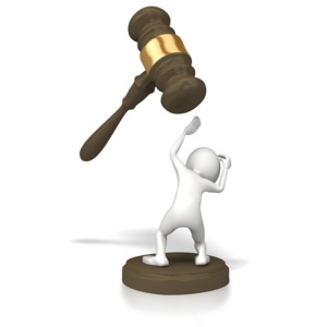 A 3D stick figure cowers in fear for a giant legal gavel in this concept of being in trouble with the law or having legal problems.