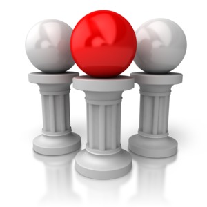 Three metallic balls stand atop Greek columns with the center ball highlighted in red.  A concept of principles, values or a single most important moral.