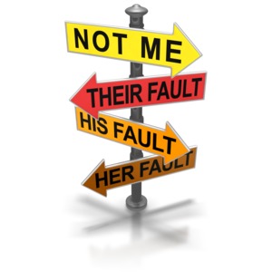 A post holds signs pointing blame elsewhere.