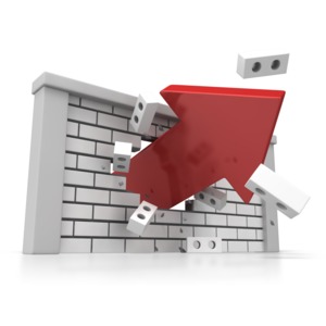 A vibrant arrow burst through the center of a large brick wall in this concept of overcoming and obstacle or breaking through a barrier.