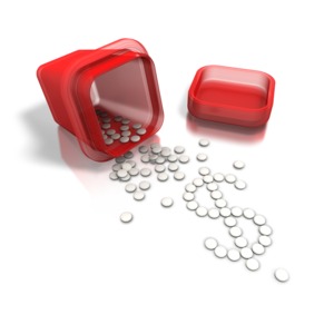 This image contains a red pill bottle with white tablets spread out on ground into the form of a dollar sign.