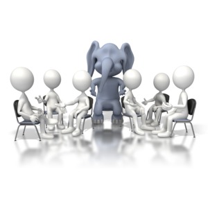 The business idiom for &#039;Ignoring the Elephant in the Room&#039; which references not addressing the major problem or overlooking the big issue.  A large elephant sits in the middle of a group meeting and is being ignored.