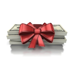 A stack of money is wrapped up with a pretty red bow in this concept of giving money or a present of cash.