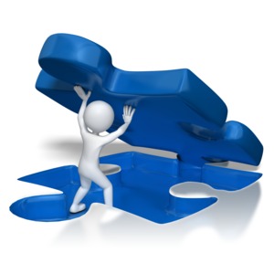 A stick figure lifts a giant puzzle piece out of the floor.