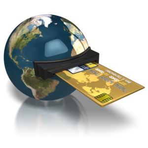 A credit card slides into a slot in the earth. This clip-art can represent global-buying power.