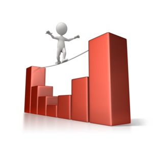 A stick figure carefully crosses on a tightrope between two peaks in a bar graph.  A concept of avoiding the valleys in an investment.