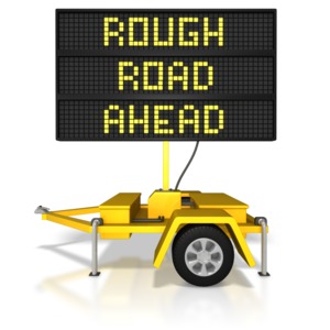 This clip art image shows a digital construction sign with the warning rough road ahead.