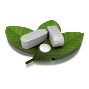 A group of herbal supplements and vitamins rest on top of a pile of leaves.  A concept of herbal remedy or natural health care.