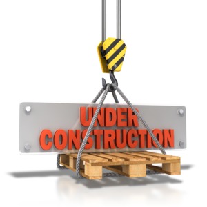 An image of an &quot;Under Construction&quot; plate on a pallet being lifted by pulley.