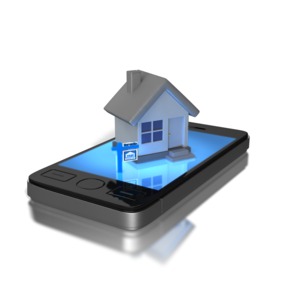 A picture of a house on top of a smart phone.