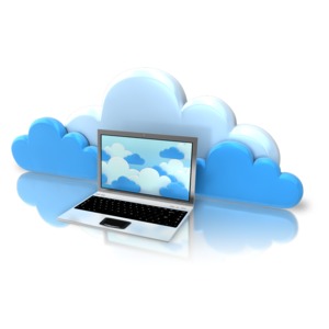 An image of a laptop computer with clouds on the screen and in front of real clouds.