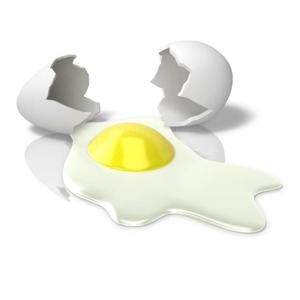 A broken egg shell spills out the egg yolk and egg white.