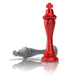 A chess concept of checkmate or victory.  A victorious chess king towers over the defeated rival.
