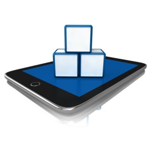 Three blocks sitting on top of a tablet.