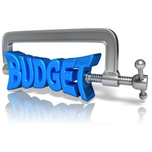 A clamp squeezes the word &#039;BUDGET&#039;. This clip-art can represent living on a budget.