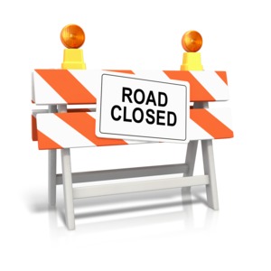 An image of a construction barricade labeled &quot;ROAD CLOSED&quot;