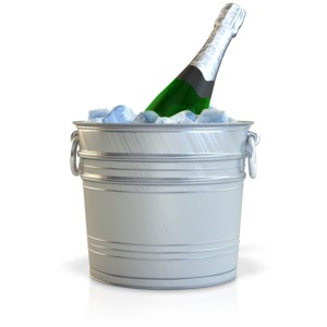 A champagne bottle chills sitting in a bucket of ice.