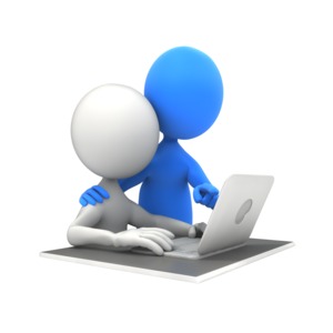 A teacher helps a student at their desk.  The student is using a laptop computer.