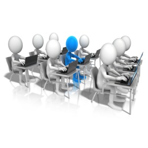 An image of a classroom working on their laptops with one student standing out.