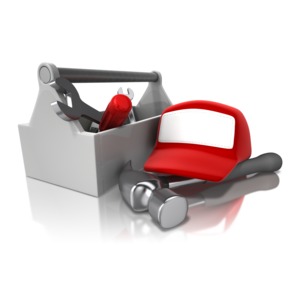 An image of a toolbox with a cap laying on top of a hammer.