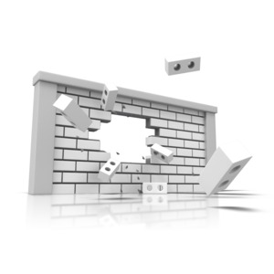 A wall is shown with a hole in it with bricks flying away from the wall.