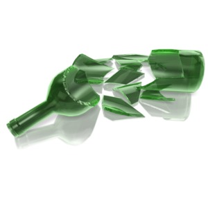 A glass bottle lays shattered on the ground.