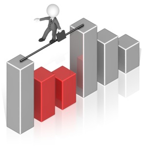 A business man walks across a gap in a bar graph.