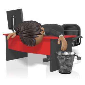 An exhausted businessman slumps over his desk.