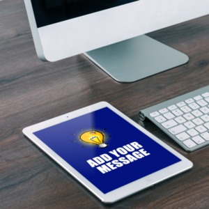 A mobile tablet device lies on a computer desk. You can customize the message on the tablet using our on-line tools.