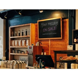 A small retail counter at a coffee shop has a wall sign that can be customized with your own message. Use our on-line tools to modify the message.