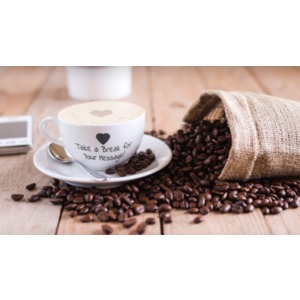 A coffee cup sits among a pile of coffee beans. You can customize the message on the site of the coffee cup using our on-line tools.