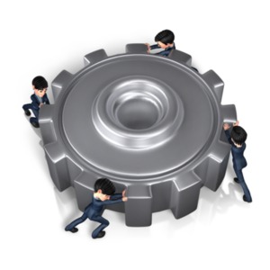 An image of a gear being pushed by 4 men.