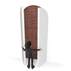 A businessman opens a doorway only to meet a brick wall blocking his way.