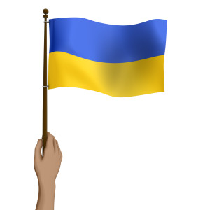 This clipart image features a raised hand holding up a smaller flag of Ukraine.  The flag has wrinkles, as it flaps in the breeze.  Use this clipart image as a representation of support or Standing With Ukraine.
