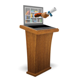 This clipart image features a laptop resting on top of a wooden podium.  An arm extends from the laptop screen presenting a diploma.  Use this visual representation of graduation from online education for all of your presentations involving graduation, education, online learning, and more.